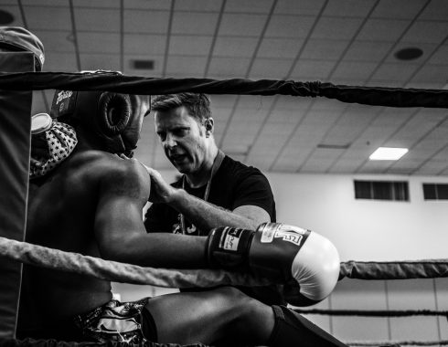 Boxer sitzt in der Ecke und wird von seinem Trainer instruiert